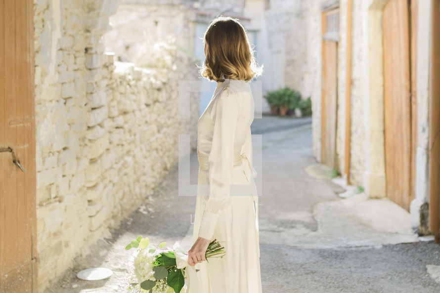 Bride in her wedding dress holding her bouquet in a village on the Mediterranean island of Cyprus.