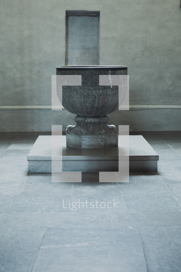 A stone baptismal font in an old cathedral 