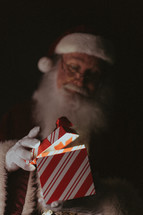 Santa opening a glowing gift 