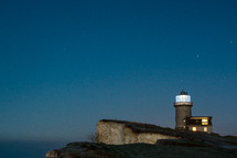 lighthouse on a cliff at night 
