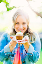 woman holding a cupcake , generosity, gift, offering