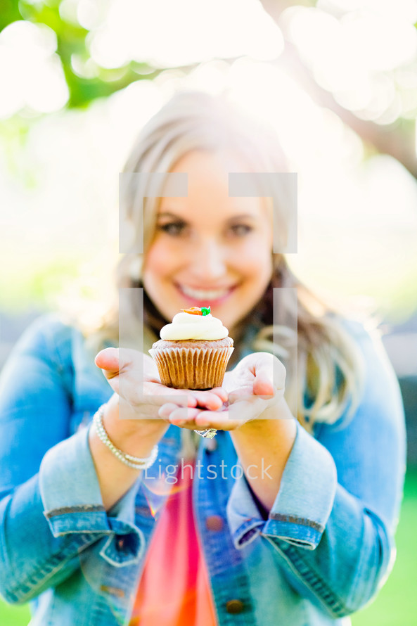 woman holding a cupcake , generosity, gift, offering