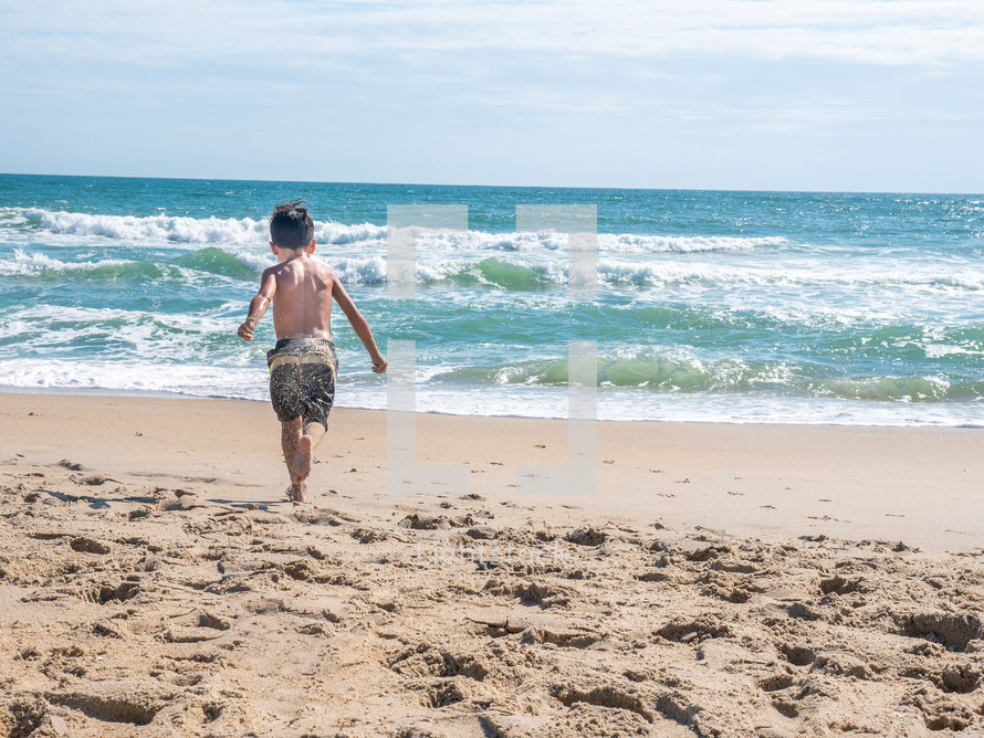 a boy running on a beach 