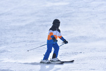 Young Skier Traveling Down a Sunny Slope 