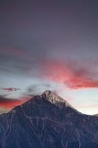 Mountain peak with pink clouds at sunset