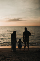 a family on a beach at sunset 