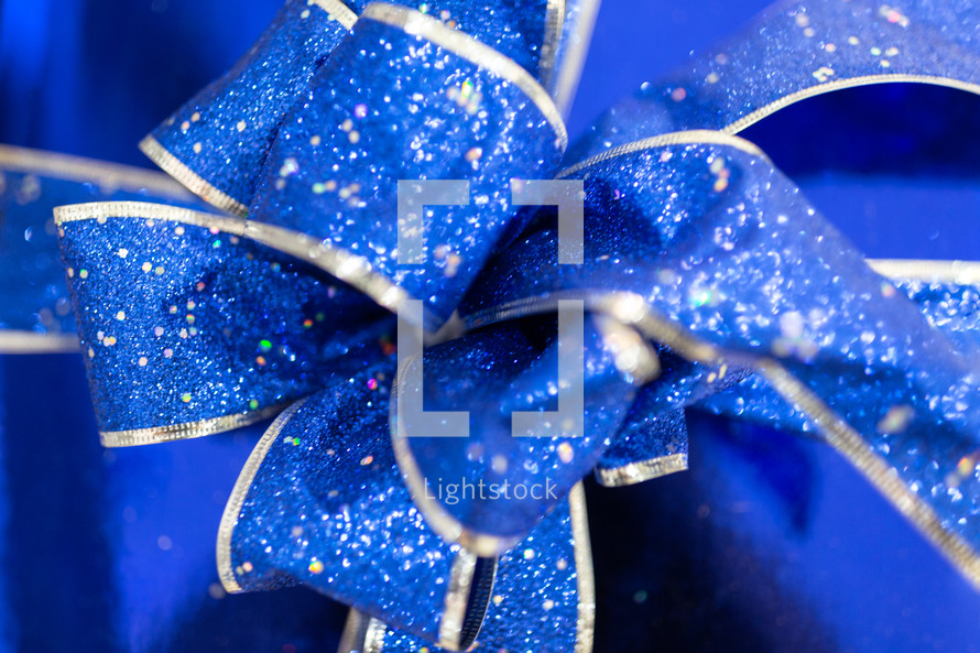 Blue ribbon bow with glitter on blue gift