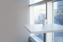 a simple cup and table near window