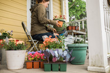 a woman on a porch planting flowers 