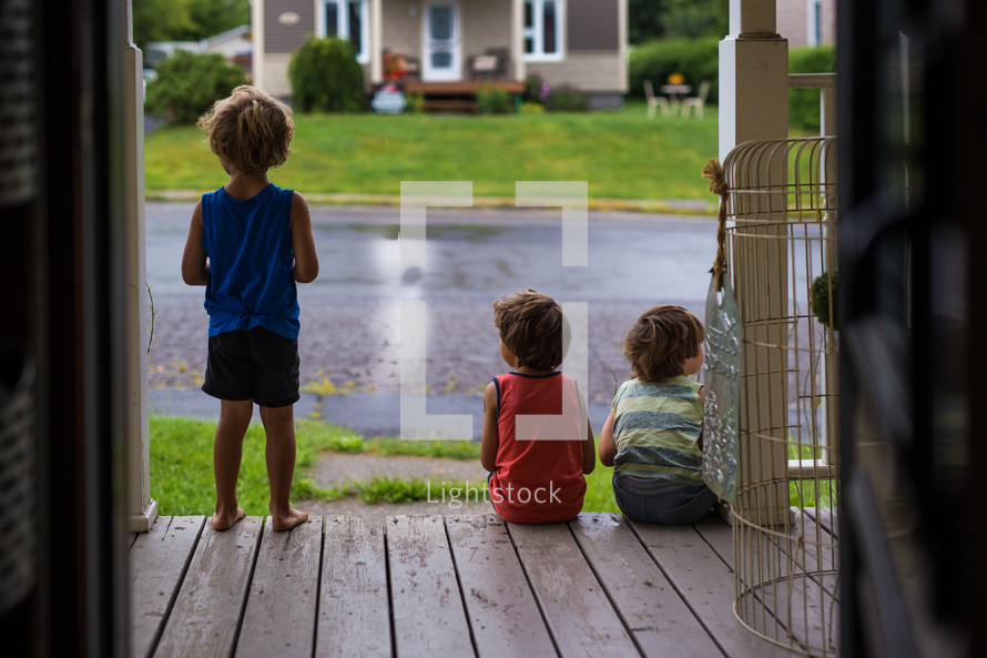 children sitting on a front porch 