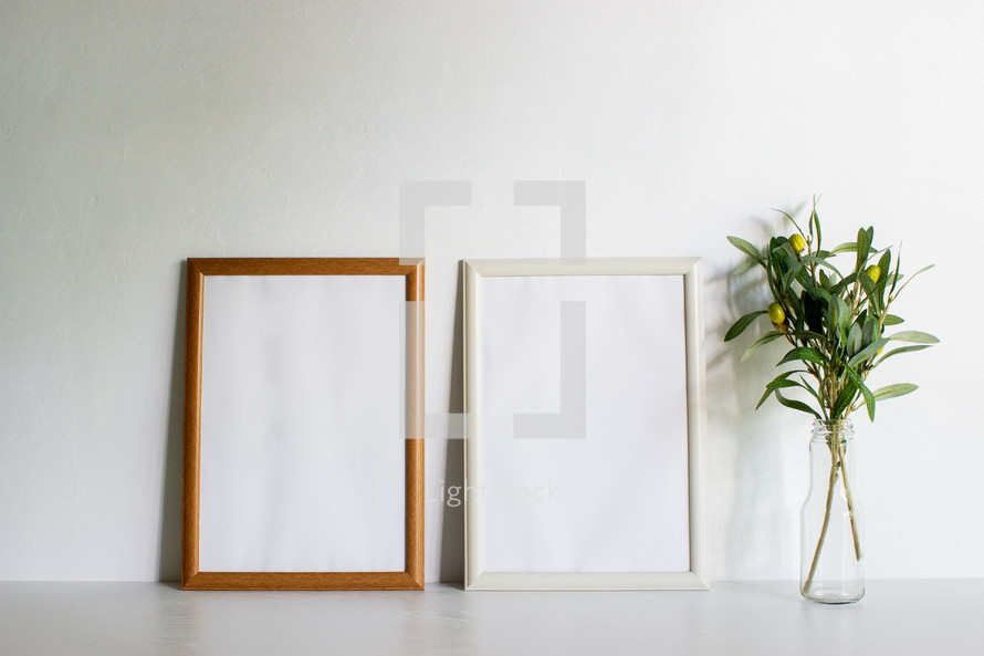 vase of olive branches and blank frame 