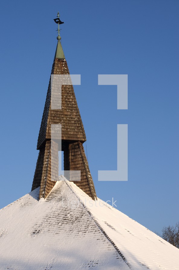 snow on a church roof and a steeple 