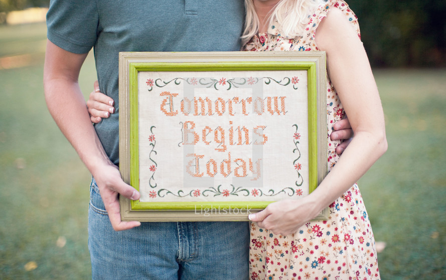 couple holding a framed picture - Tomorrow Begins Today