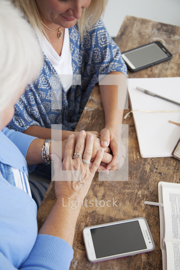 holding hands in prayer at a woman's group Bible study 