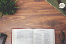 open Bible and reading glasses on a wood table - Lamentations