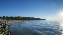 sunbathers on a lake shore 