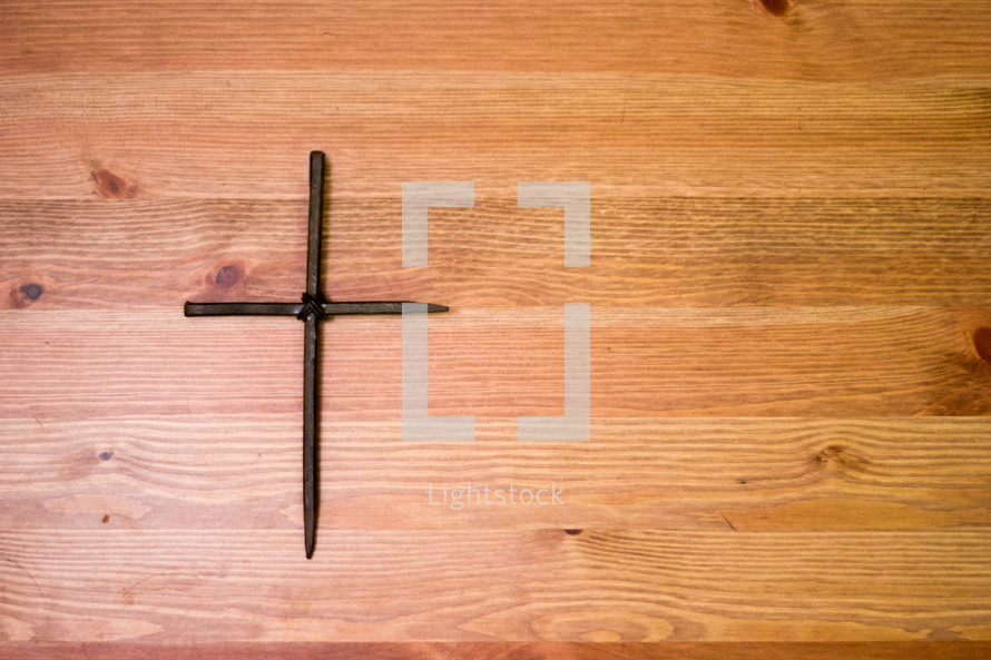 cross of nails on wood background 
