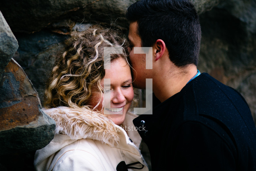 man kissing a woman on the cheek