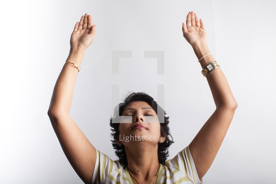 a woman with hands raised in prayer 