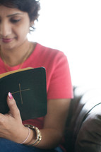 a woman sitting and reading a Bible 