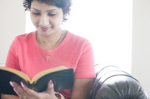 a woman sitting reading a Bible
