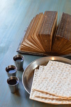 The Lord's Supper with bread, wine and an ancient open bible. 