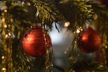 red ornaments and tinsel on a Christmas tree