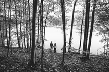 a couple standing outdoors by a lakeshore 