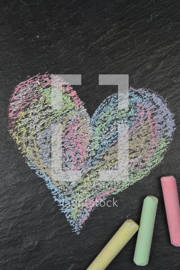 heart shape in sidewalk chalk on slate with copy space above