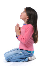 young girl, kneeling on floor with hands folded in prayer