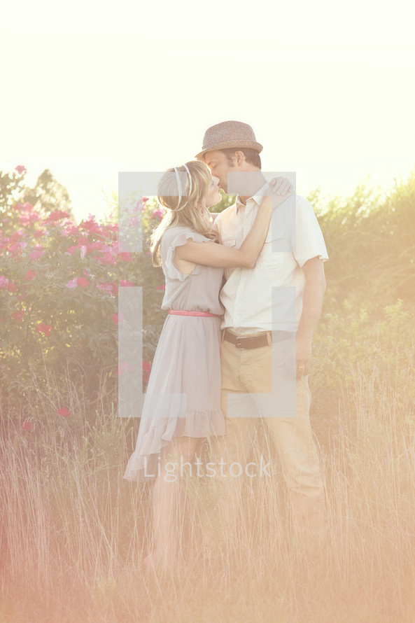 A kiss in a field of flowers.