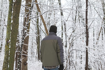 man standing outdoors in a forest in winter 