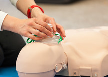 Female instructor showing CPR on training doll