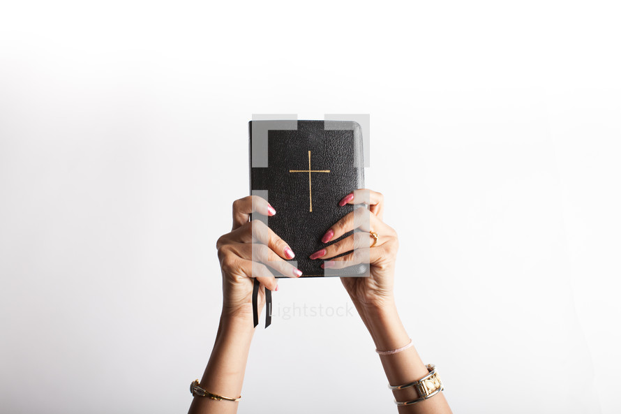 a woman holding up a Bible 