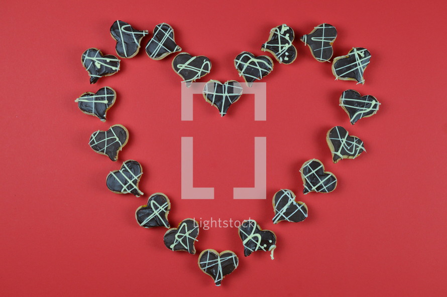 home made heart shaped cookies with chocolate on red background shaping a big heart