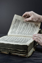 hands turning the pages of a Bible 