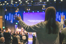 parishioners with raised hands during a worship service 