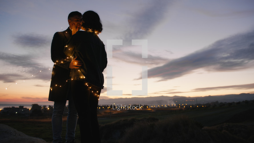 Silhouette of couple embrace together against the sunset during valentine's day