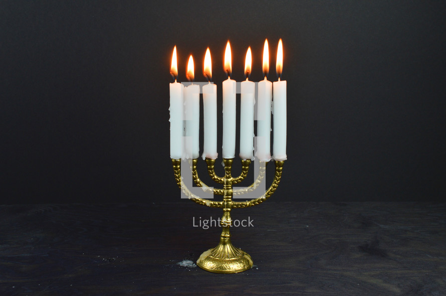 golden menorah with seven burning candles