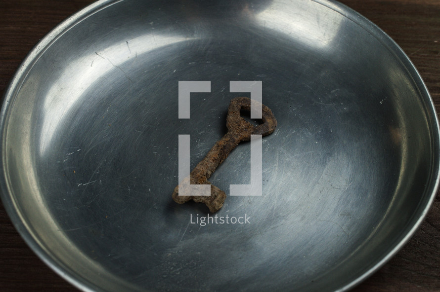 rusty key on an ancient pewter plate
