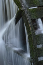 water flowing over a wheel at a mill 