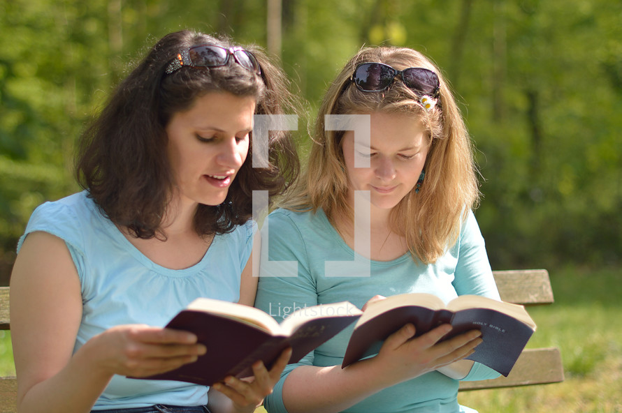 women reading Bibles together outdoors 