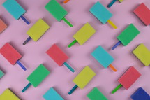 pattern out of multicolored sponge popsicles on pink background as thank you for the volunteer cleaning team in church or as decoration for the vacation bible school in the classroom