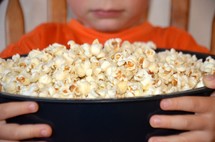 boy holding a bowl of popcorn 