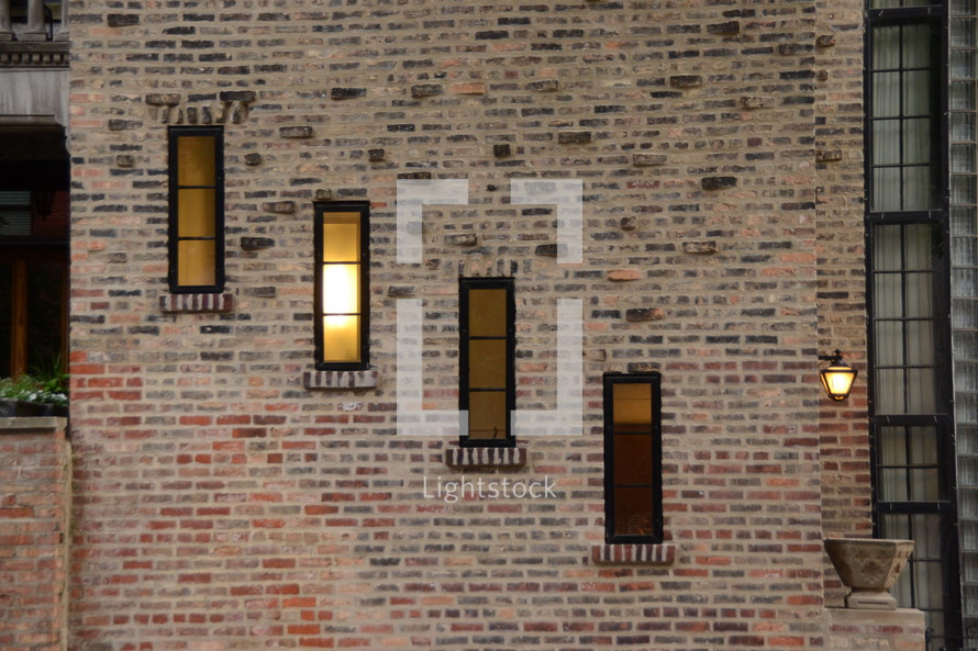 A brick wall with narrow rectangular windows.