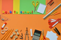 School supplies on colorful paperboard and the words BACK TO SCHOOL