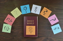 Holy Bible and question marks on sticky notes 