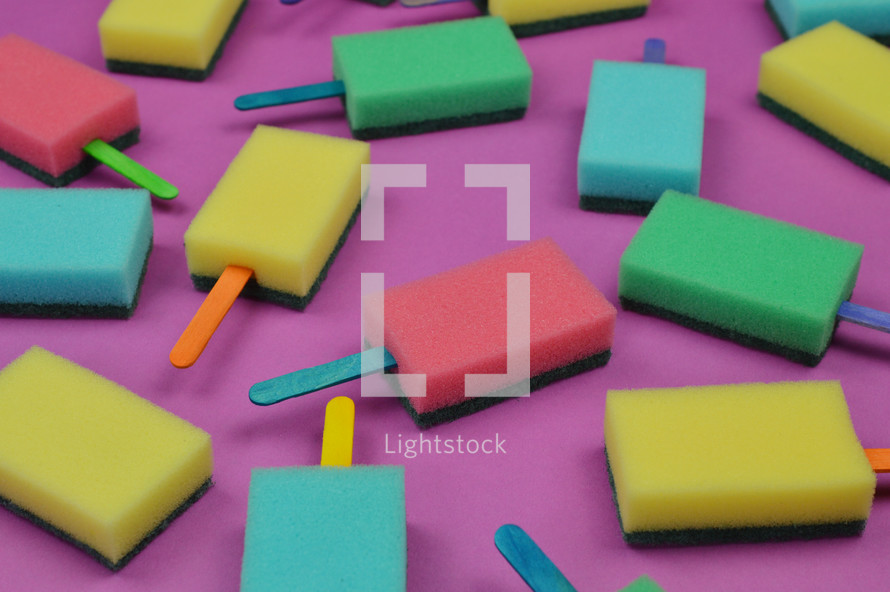 multicolored sponge popsicles on pink background as thank you for the volunteer cleaning team in church or as decoration for the vacation bible school in the classroom