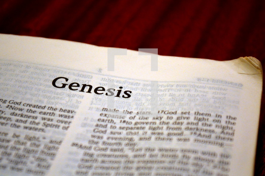 A Bible opened to the first page of Genesis.