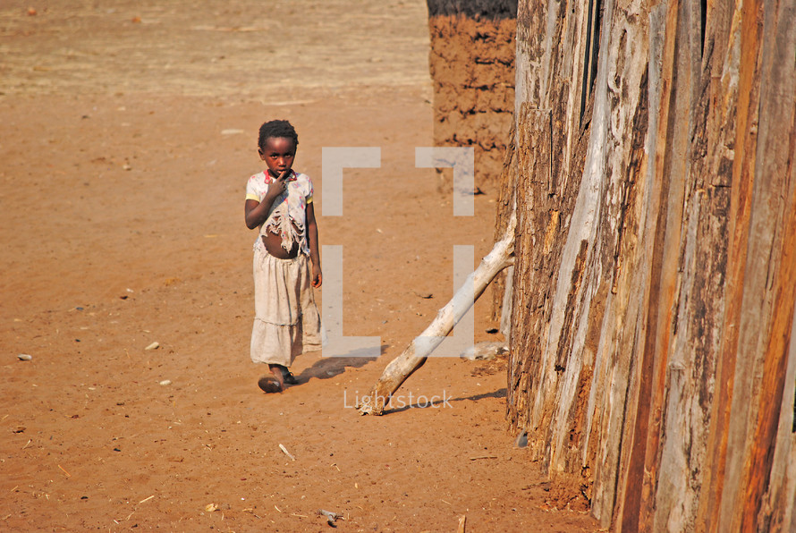 a child walking in a desert village 